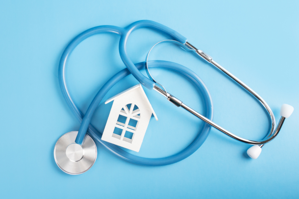 Stethoscope on a blue background with a small model house