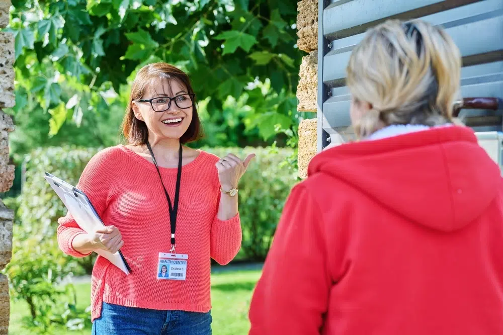 Health worker talking outside a gate